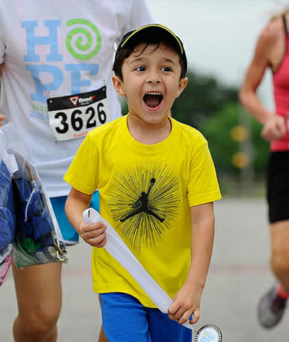 Young boy with huge smile, participating in 2nd Chance Run