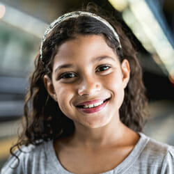 Young girl looking at camera, smiling